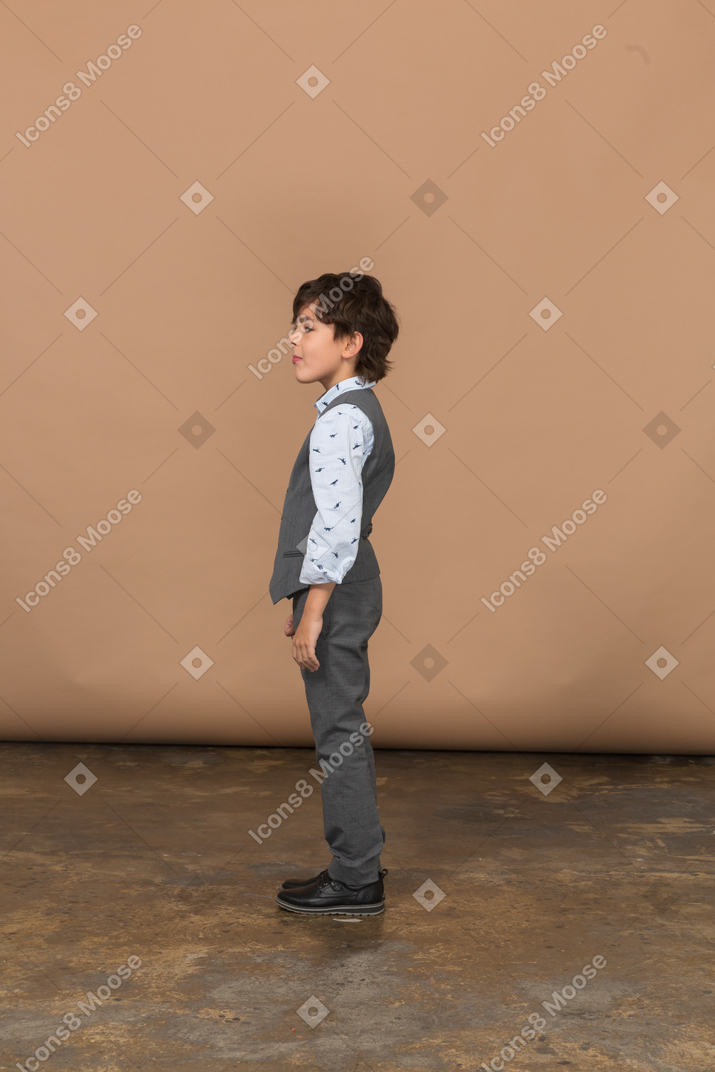 Vista lateral de um lindo garoto de terno cinza
