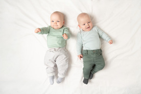 Babies twins lying on the back next to each other