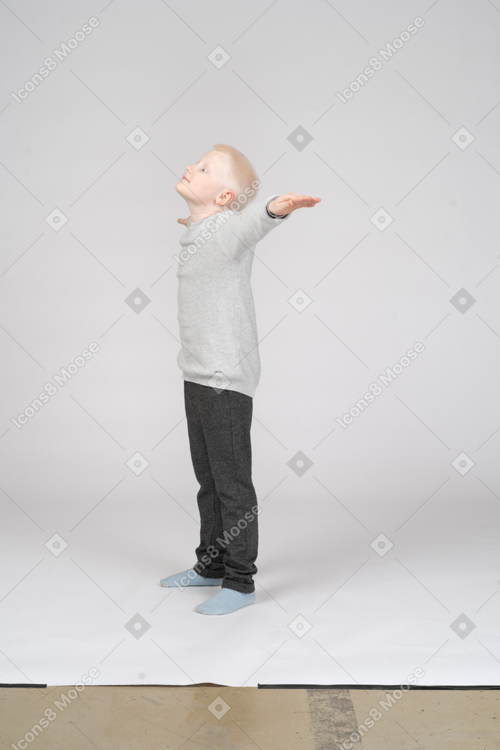 Side view of a boy with his hands stretched to the side