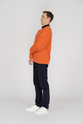 Young man in orange sweatshirt standing