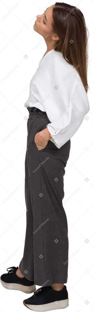Vue latérale d'une jeune femme en vêtements de bureau mettant les mains dans les poches