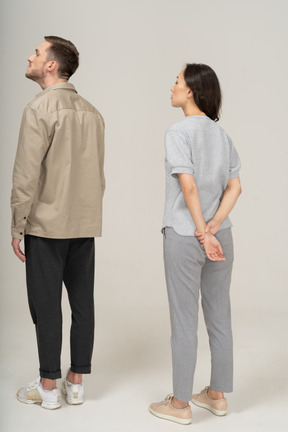 Three-quarter back view of young couple pulling their necks