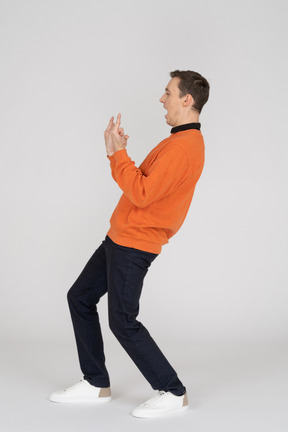 Young man in orange sweatshirt standing