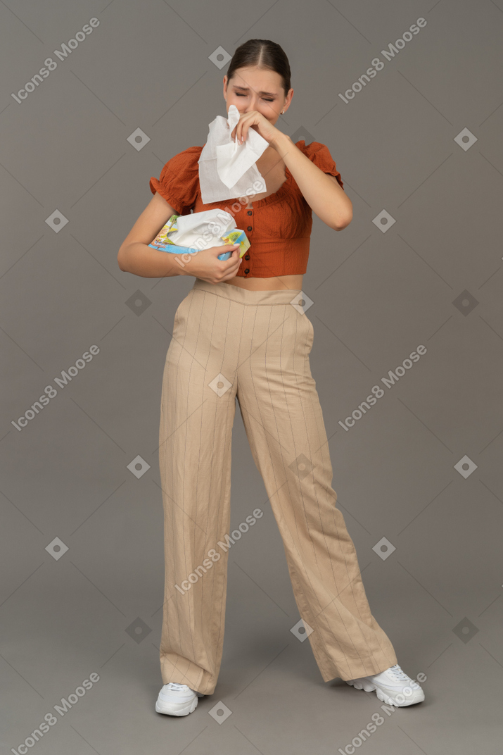 Вид спереди на молодую женщину, плачущую с салфеткой в руках