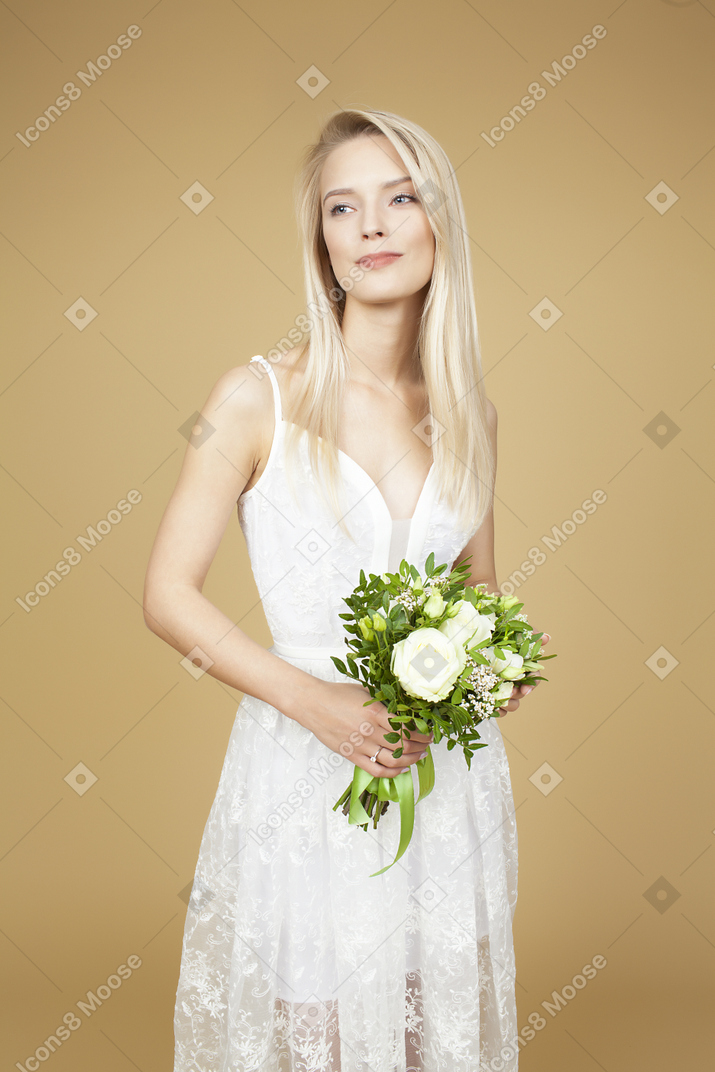 Beautiful bride holding bouquet and posing for a picture