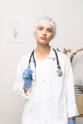 Vista frontal de una joven doctora sosteniendo estetoscopio