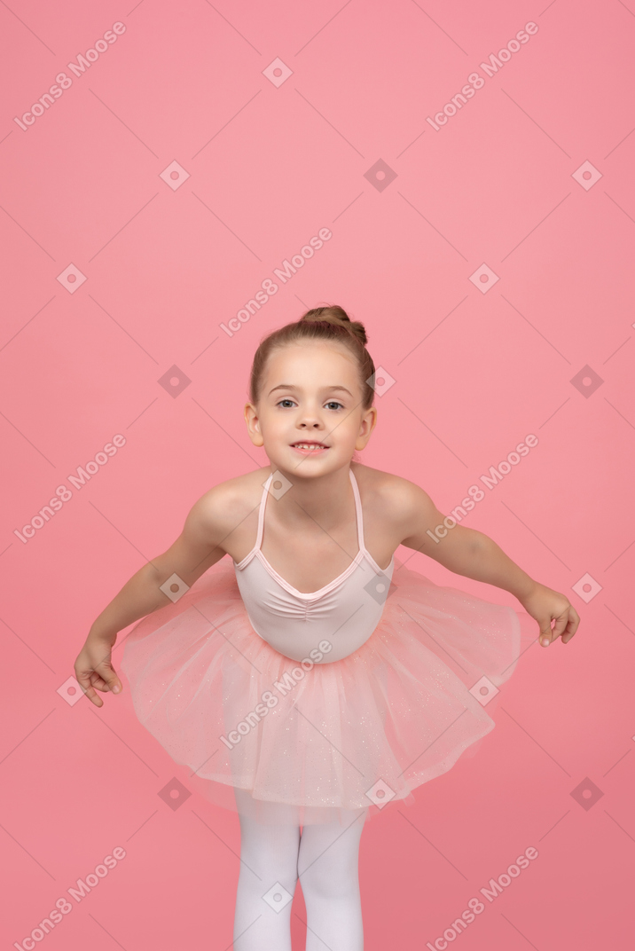 Ballerina leaning forward with her hands aside