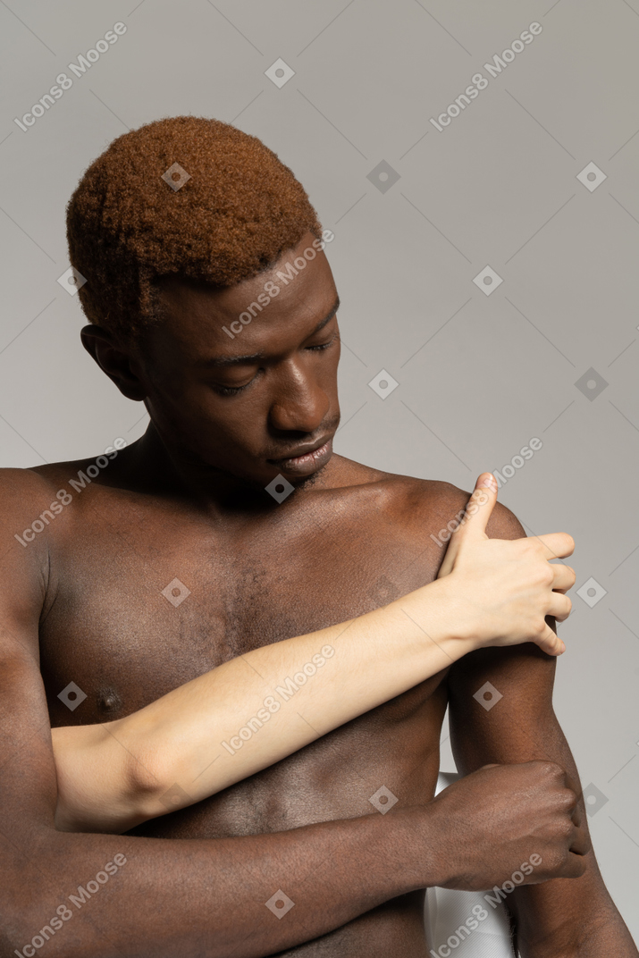 White hand touching the shoulder of a black man