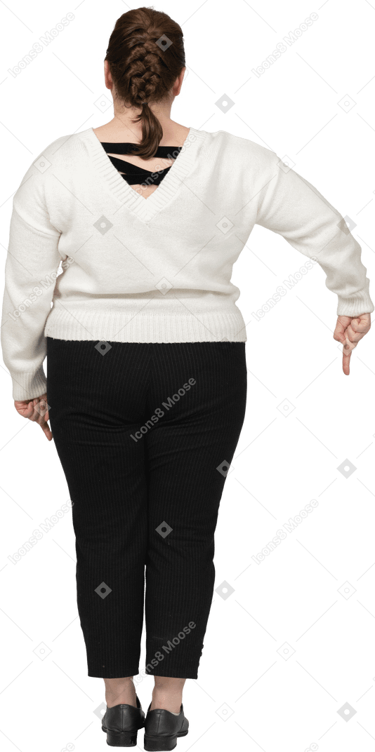Femme de taille plus dans des vêtements décontractés pointant vers le bas avec un doigt