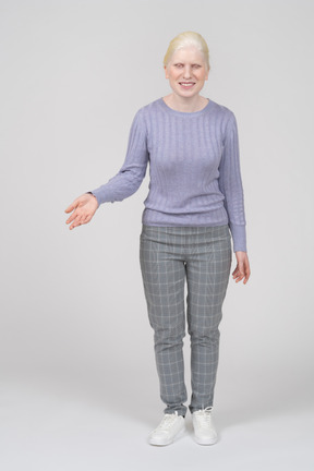 Vista frontal de una mujer joven con ropa informal extendiendo la mano