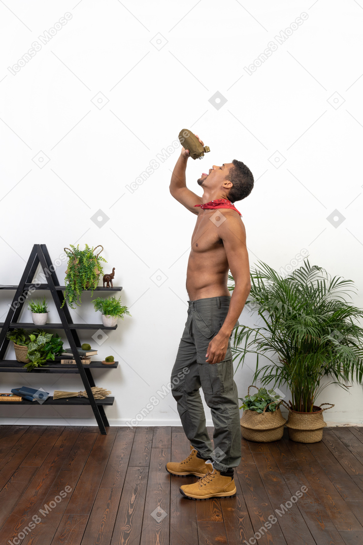 Good looking young man drinking from the flask