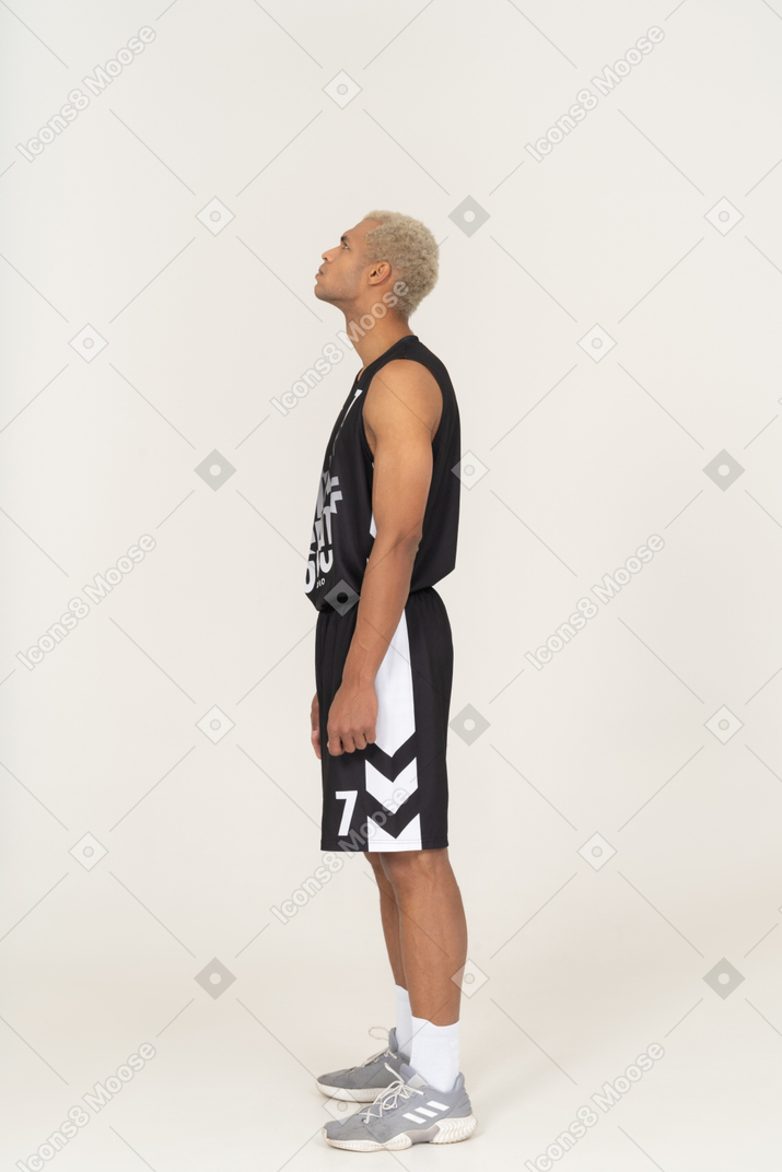 Side view of a young male basketball player looking up