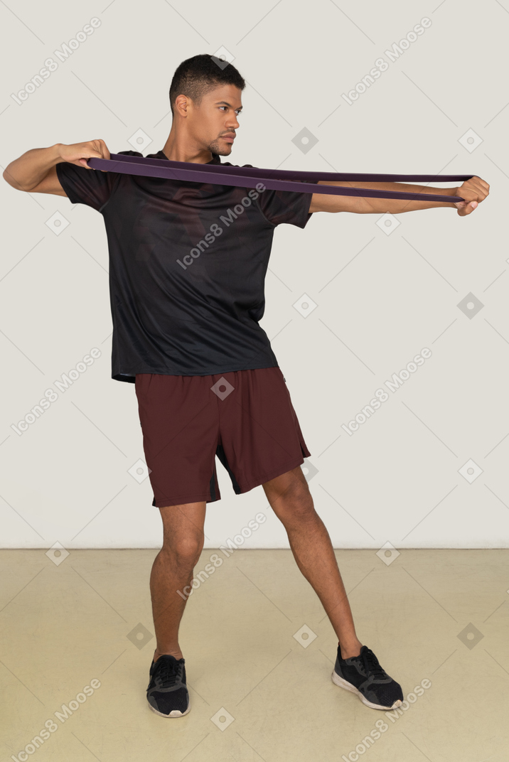 Молодой человек в спортивной одежде делает упражнения