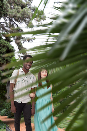 Una linda pareja interracial feliz caminando juntos en una selva tropical