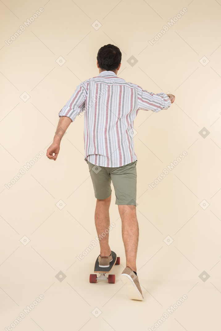 Young caucasian guy standing on skate