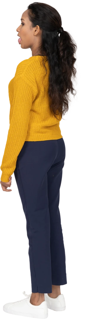 Side view of a girl in casual clothes looking aside and showing tongue