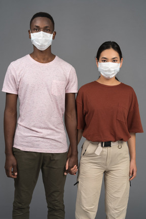 A young couple wearing face masks