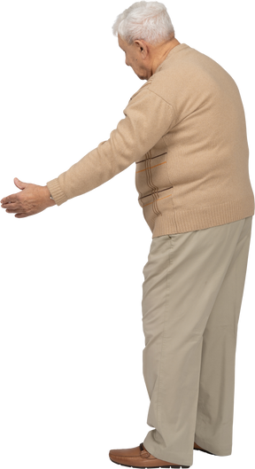 Вид сбоку на старика в повседневной одежде, делающего приветственный жест