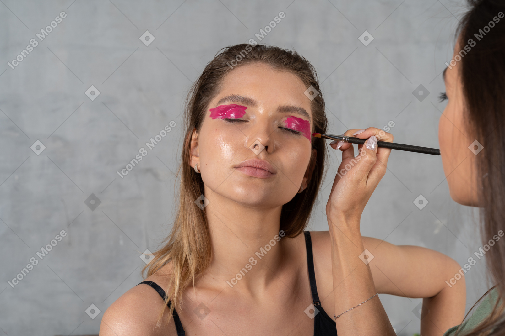 Retrato de uma jovem com os olhos fechados esperando que sua maquiagem seja finalizada