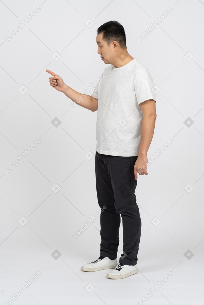 Side view of a serious man pointing at something